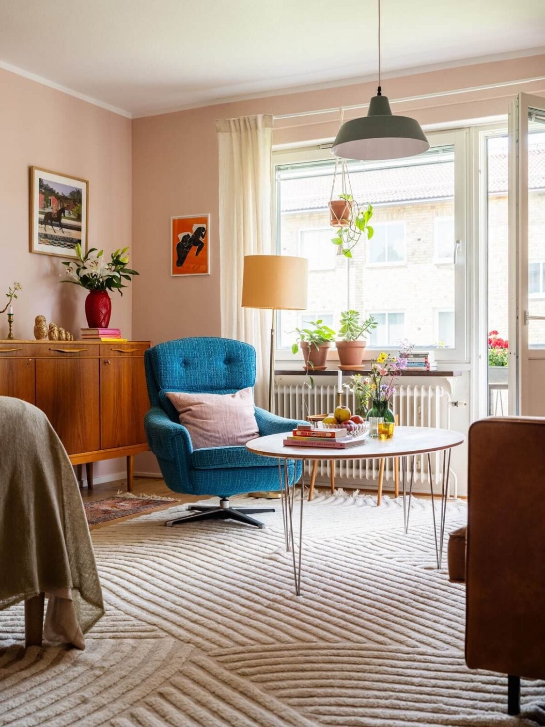 A Studio Apartment with Light Pink Walls and Vintage Furniture 2 studio apartment striped rug and red chair