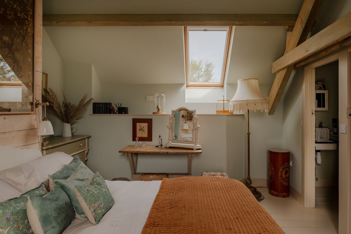 Cottage-Style Interiors in an English Barn Conversion 12 warm attic bedroom wooden beams
