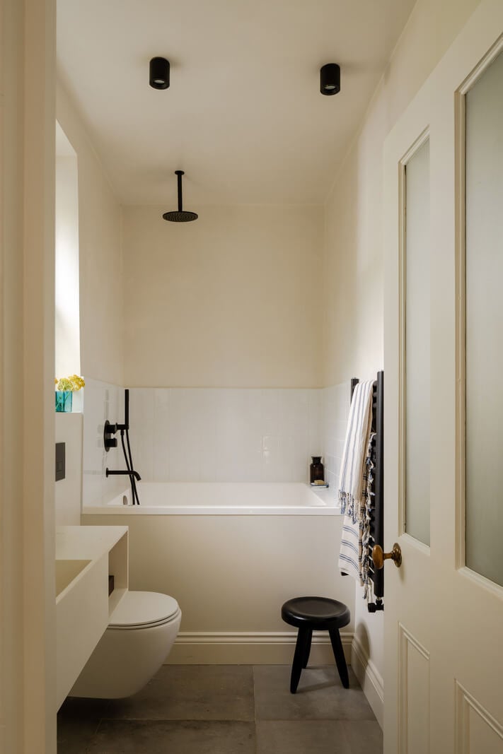 Pared Back Interiors and Light-Filled Spaces in a London Apartment 14 white bathroom with black fittings