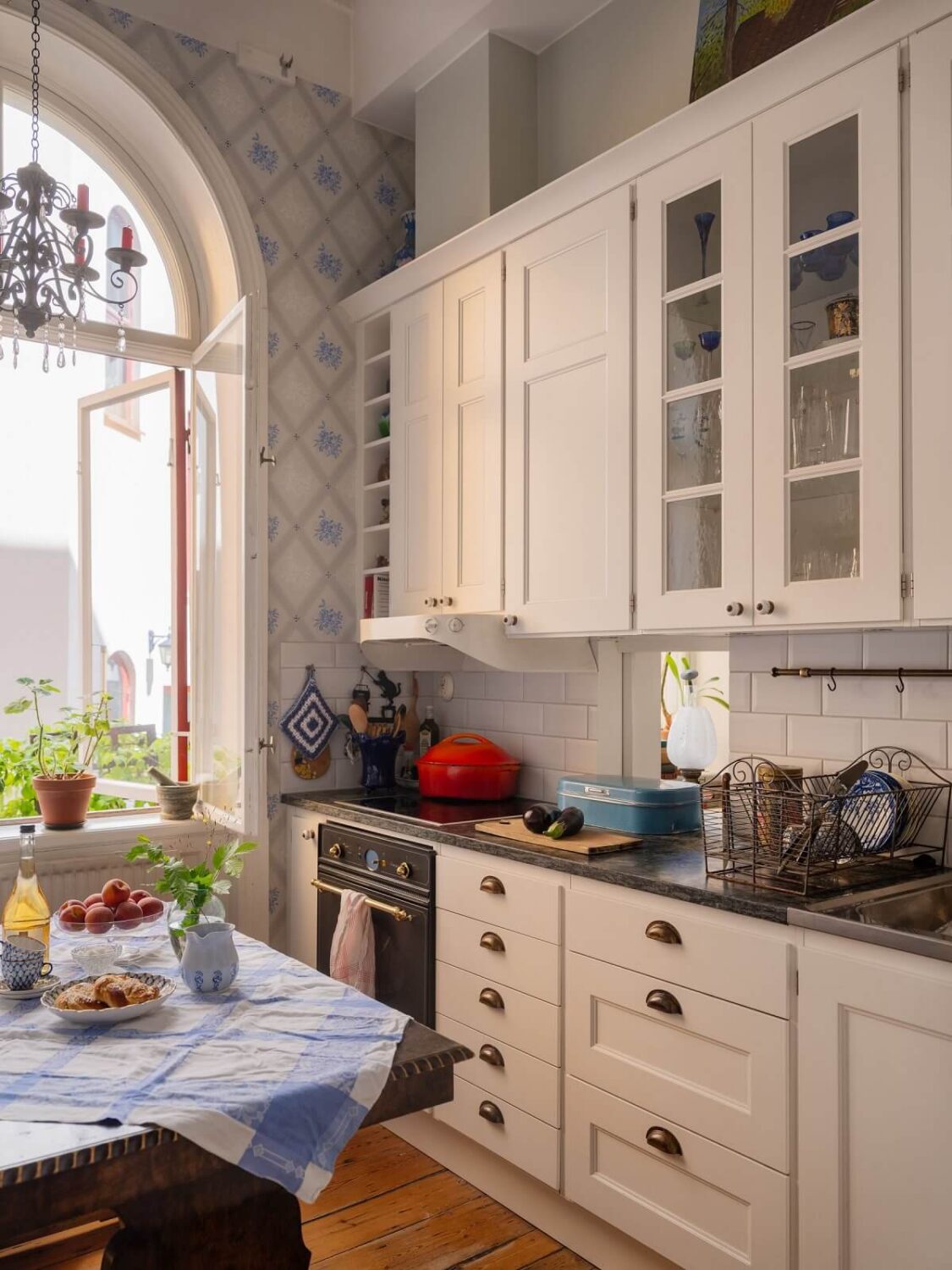 Antique Furniture and Arched Windows in a Stockholm Apartment 10 white kitchen with light blue wallpaper and arched window nordroom