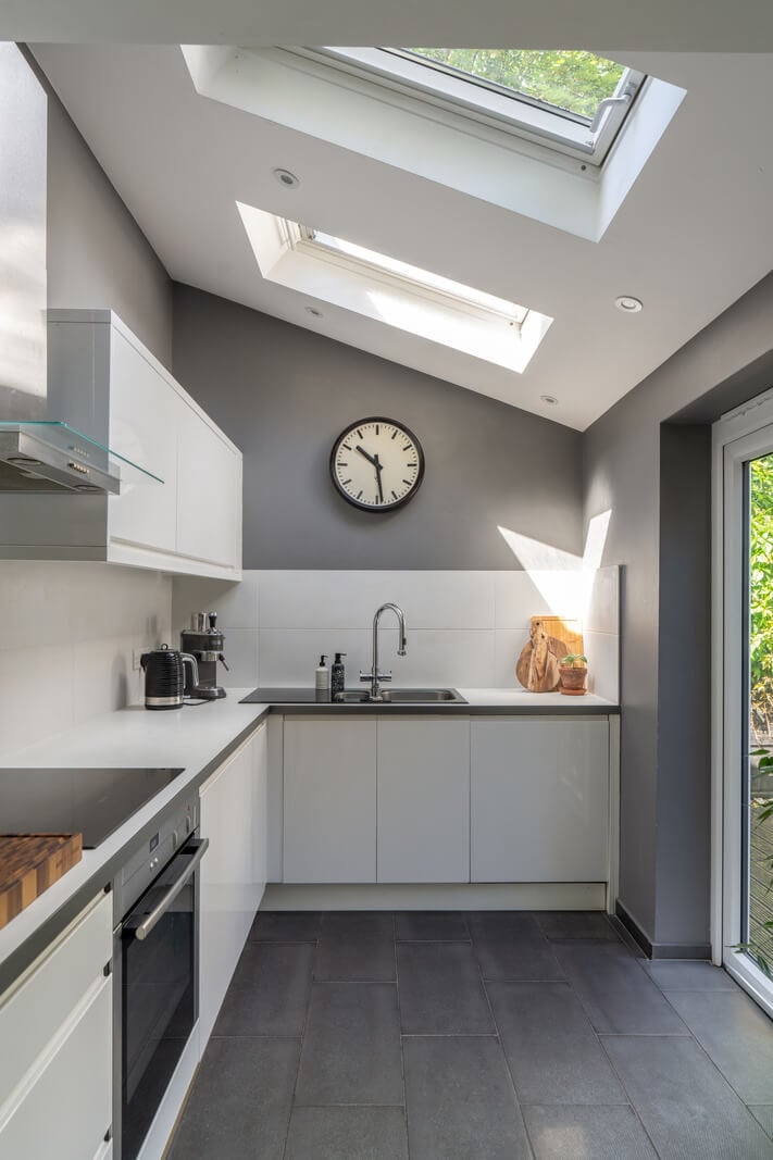 Blue Tones in a Two-Bedroom Victorian Cottage 8 white kitchen with skylights
