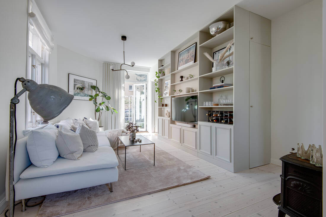 A White Apartment Features a Beautiful Terrace with a View 4 white scandi living room with floor to ceiling cabinets