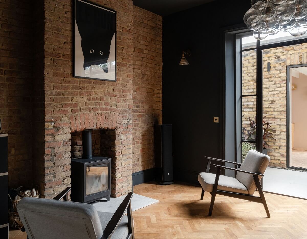 A Stunning Color Palette in an Extended Edwardian House in London 7 wood burner set in brick wall and black ceiling