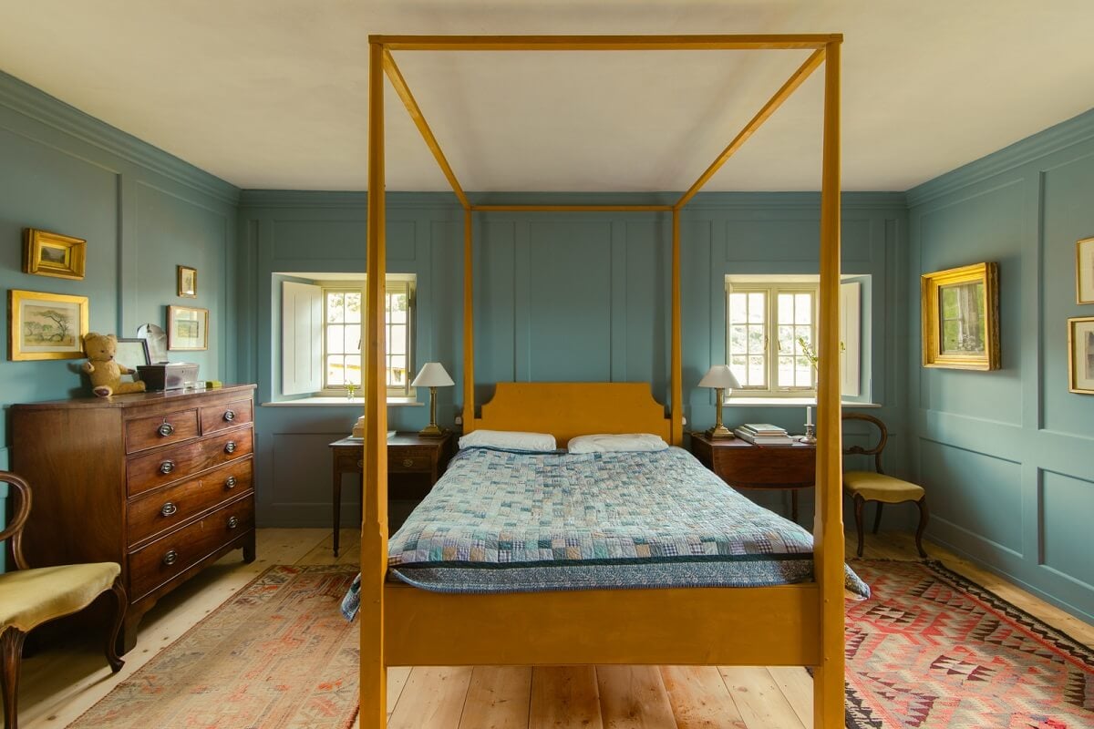 A Yellow Farmhouse with Bold Color Pops in Wales 22 yellow canopy bed in bedroom with blue walls