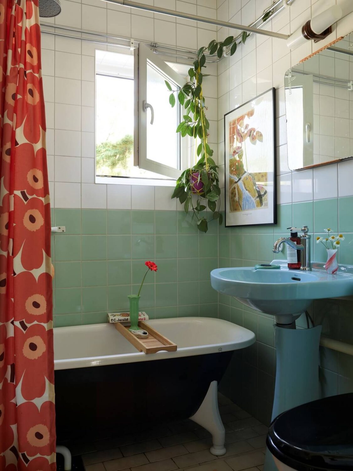A Colorful Swedish Apartment Inspired by the 50s and 70s 27 bathroom mint green tiles blue sink and clawfoot bath nordroom