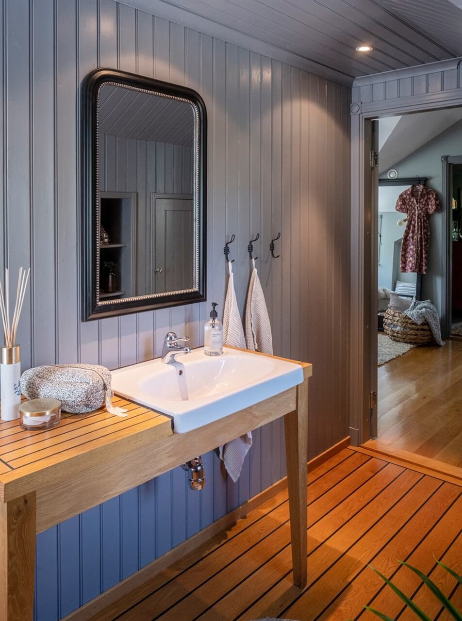 A White Swedish Villa with a Veranda and a Swimming Pool 18 bathroom with gray blue paneled walls nordroom