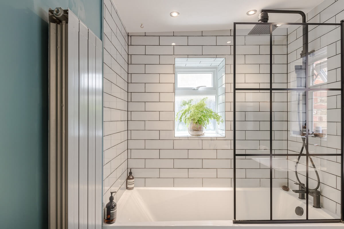 A London Apartment with a Deep Olive Green Kitchen 11 bathroom with shower and bath combination and white subway tiles nordroom