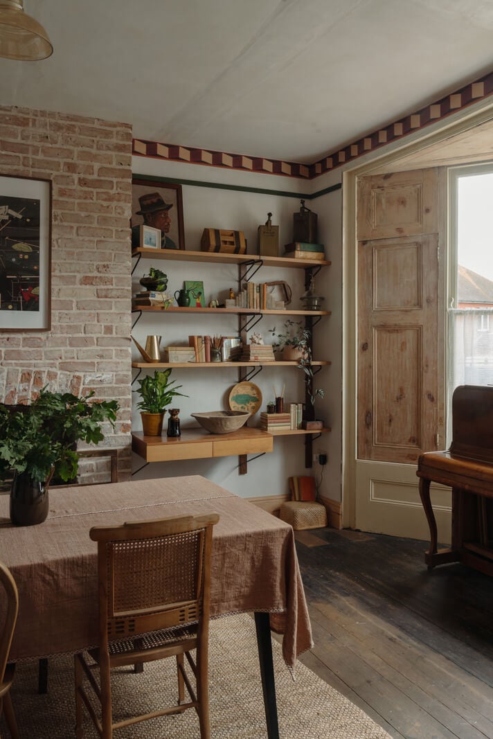 Pared Back Interiors in an English Home in Kent 8 brick fireplace flanked by shelves dining room