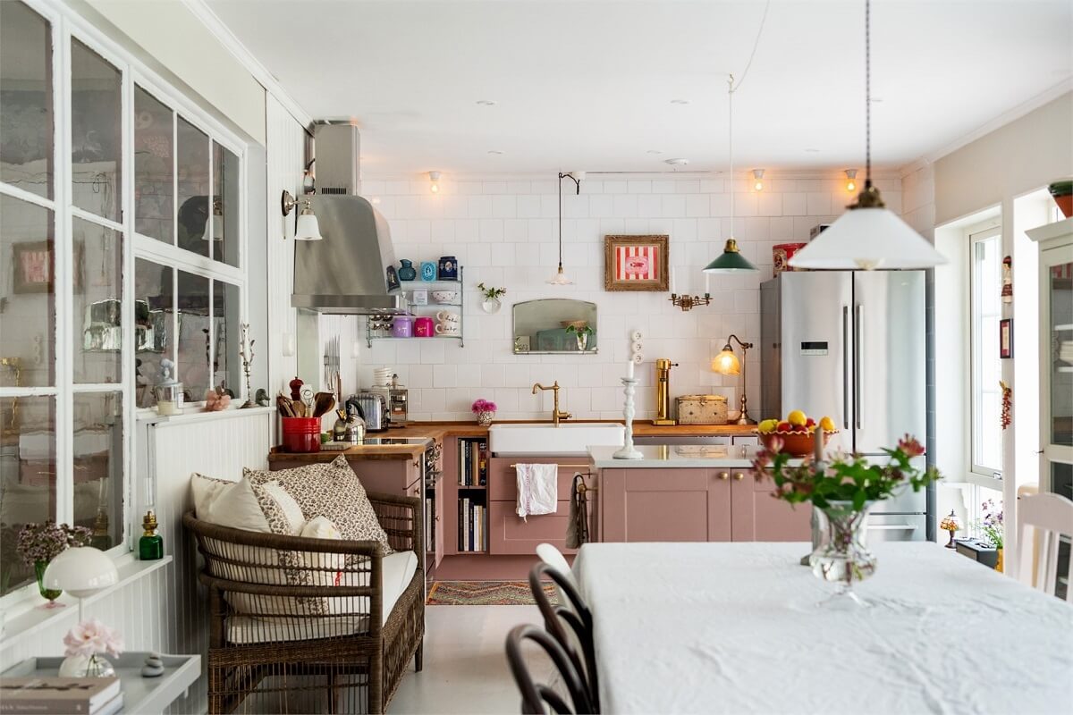 A Bright Open-Plan Swedish Home with a Pink Kitchen 13 cozy pink kitchen with bench and dining table