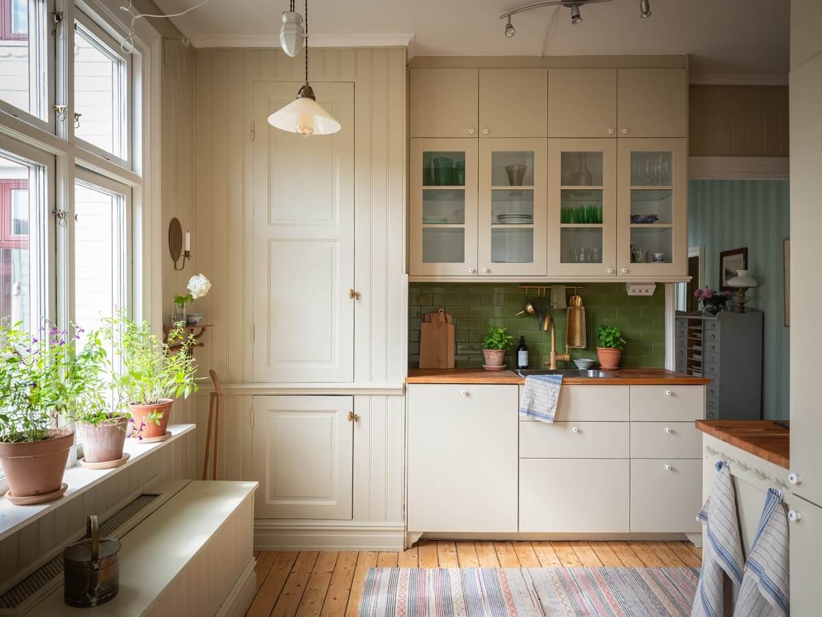 Charming Vintage Country Style in a Family Apartment in Sweden 11 cream kitchen with green backsplash tiles nordroom