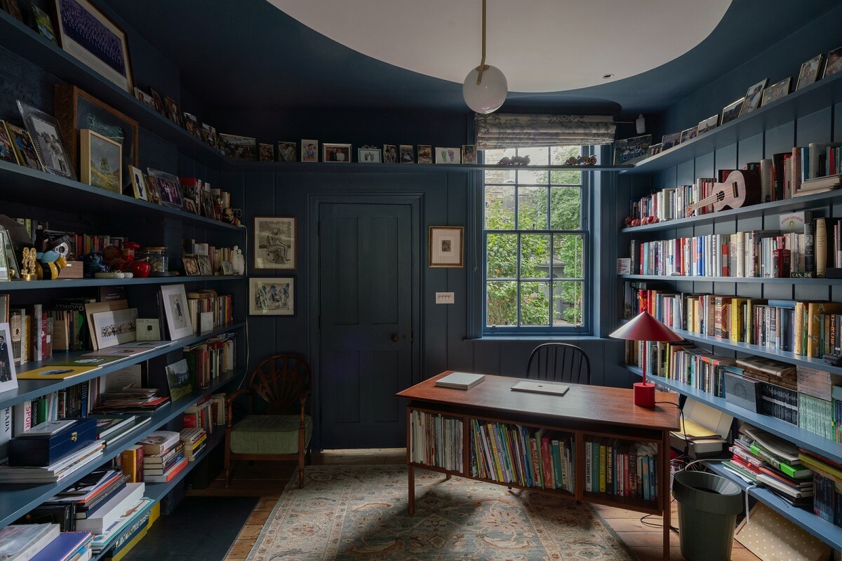 A Beautiful London Family Home with Colorful Accents 4 dark blue home office with bookshelves and midcentury desk nordroom
