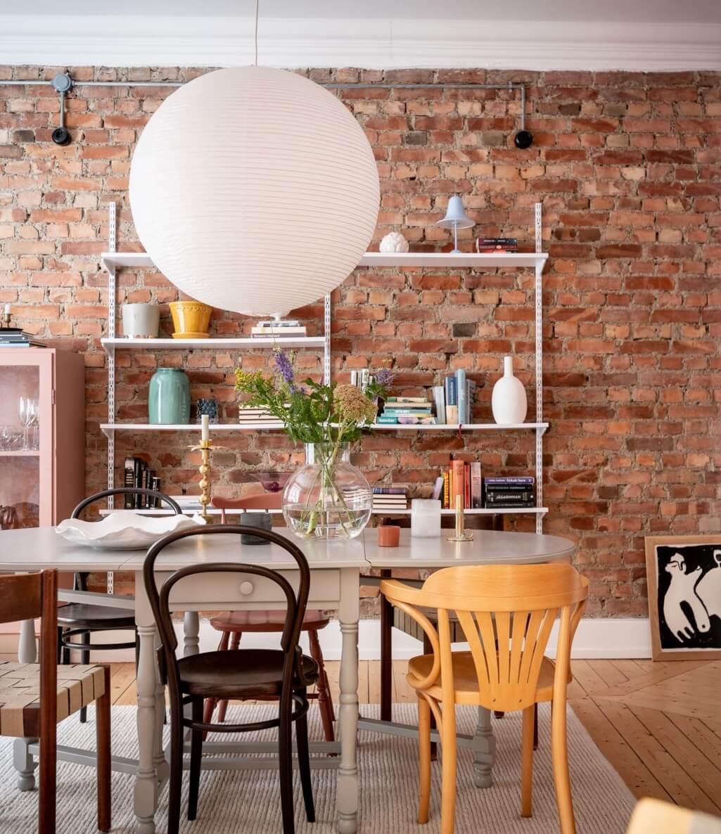 A Scandinavian Apartment with a Pale Yellow Living Room 9 dining room with exposed brick wall