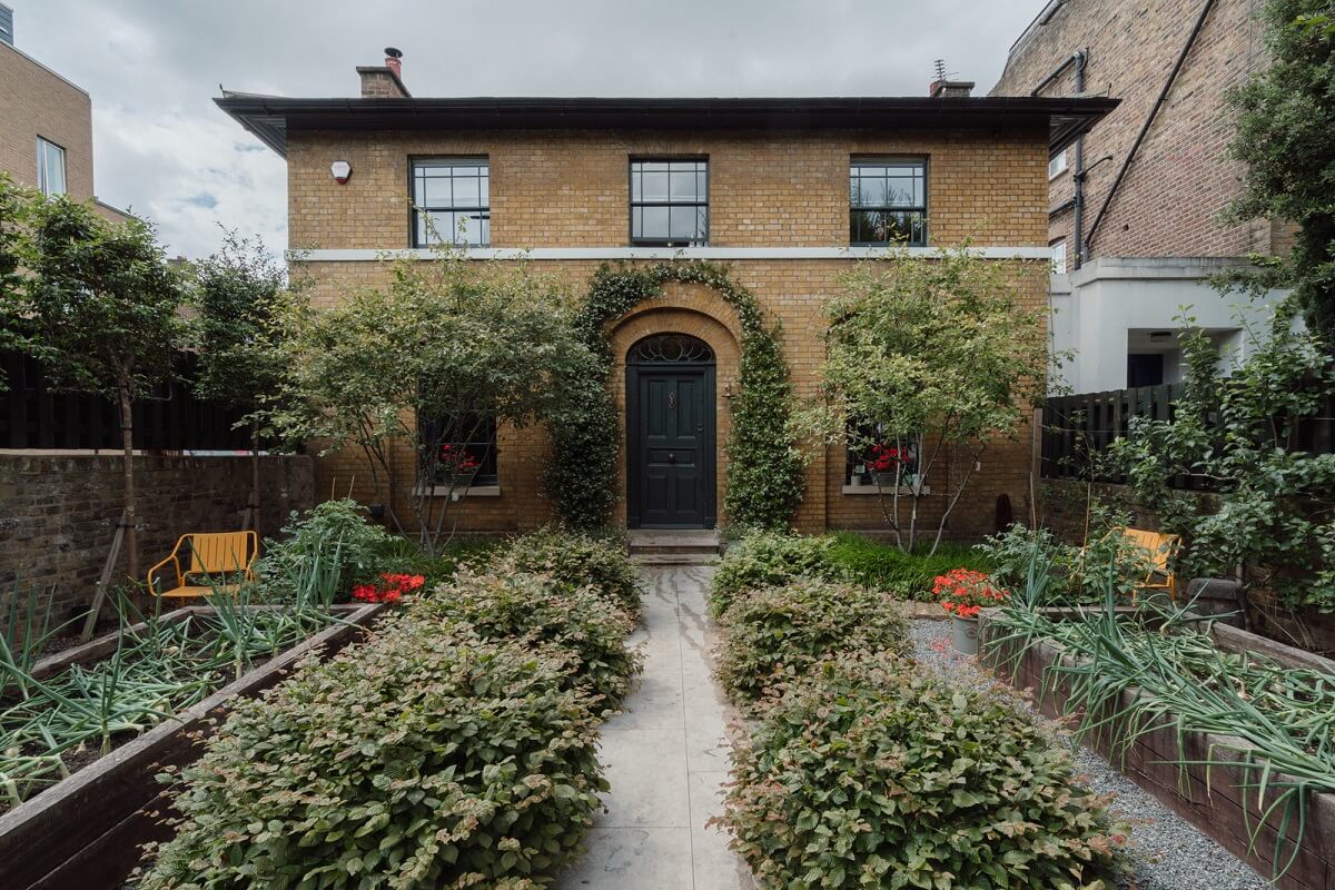 A Beautiful London Family Home with Colorful Accents 30 exterior garden london home with dark green front door nordroom A Beautiful London Family Home with Colorful Accents