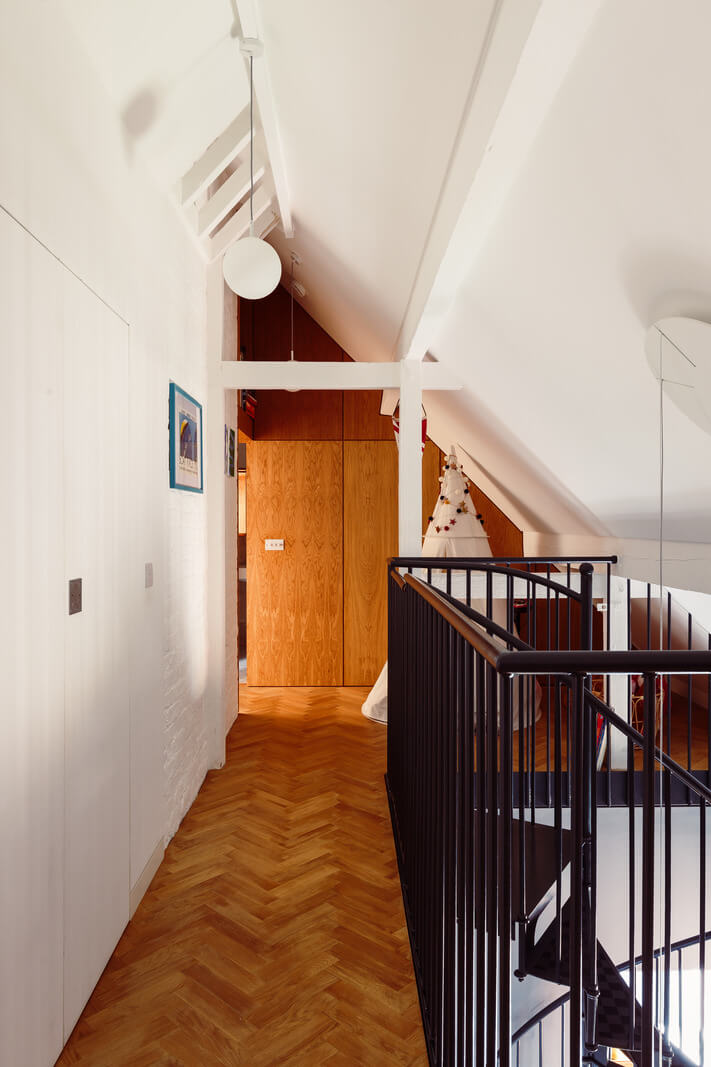 A London Duplex Apartment with a Purple Kitchen 17 first floor landing slanted ceiling herringbone floor