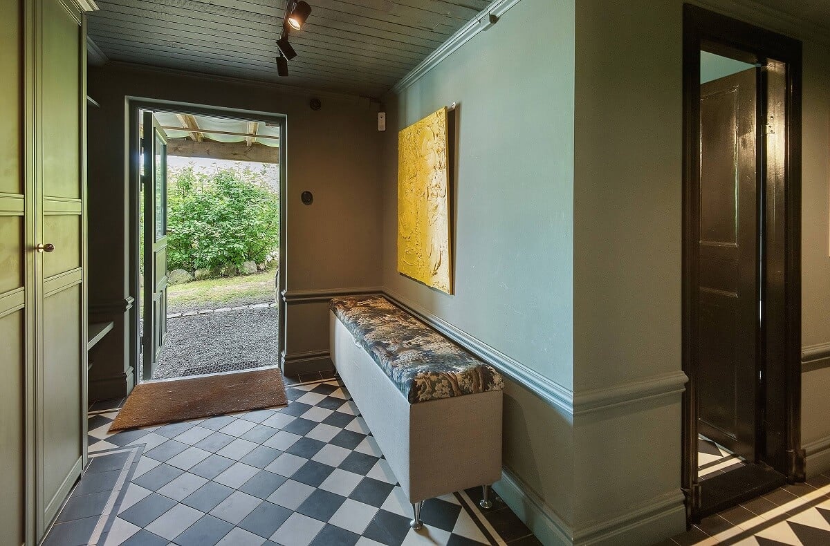 A Yellow Swedish Villa with Views of the Sea 10 green hallway with bench and checkerboard floor nordroom