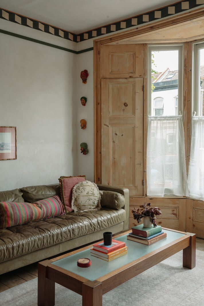 Pared Back Interiors in an English Home in Kent 3 green sofa bay window wooden shutters nordroom
