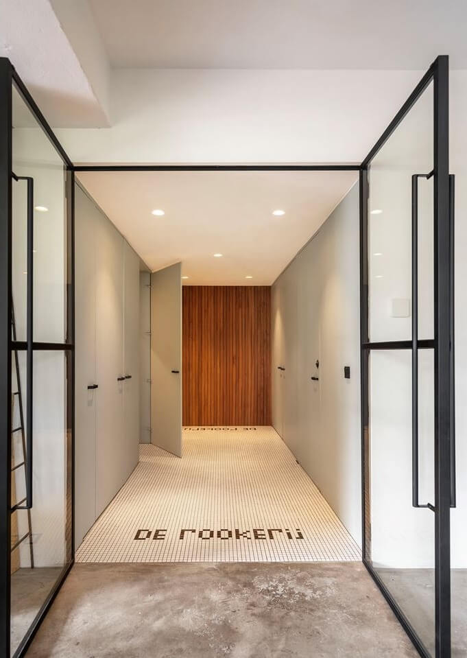 An Old Smokehouse Transformed Into a Modern Industrial Home 17 hallway with industrial glass doors and built in cabinets