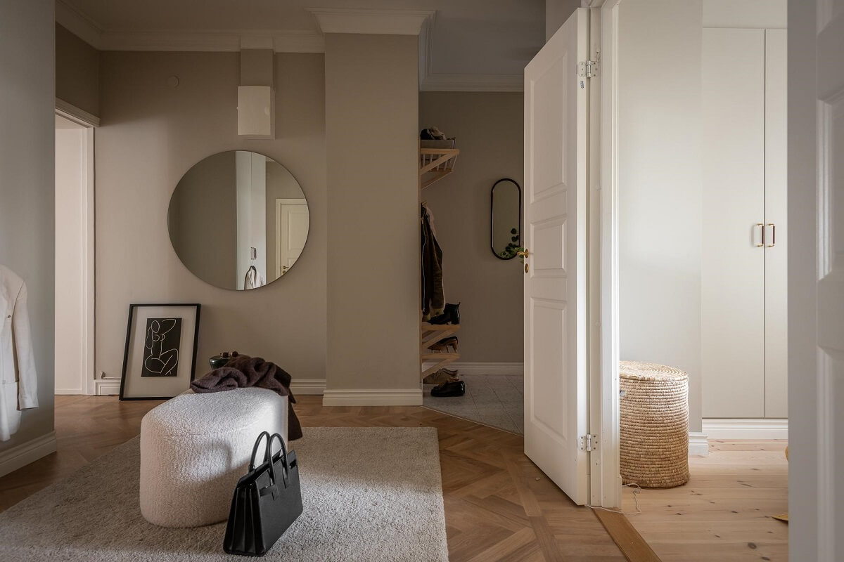 A Spacious Renovated Apartment with a Light Pink Living Room 28 hallway with large round mirror