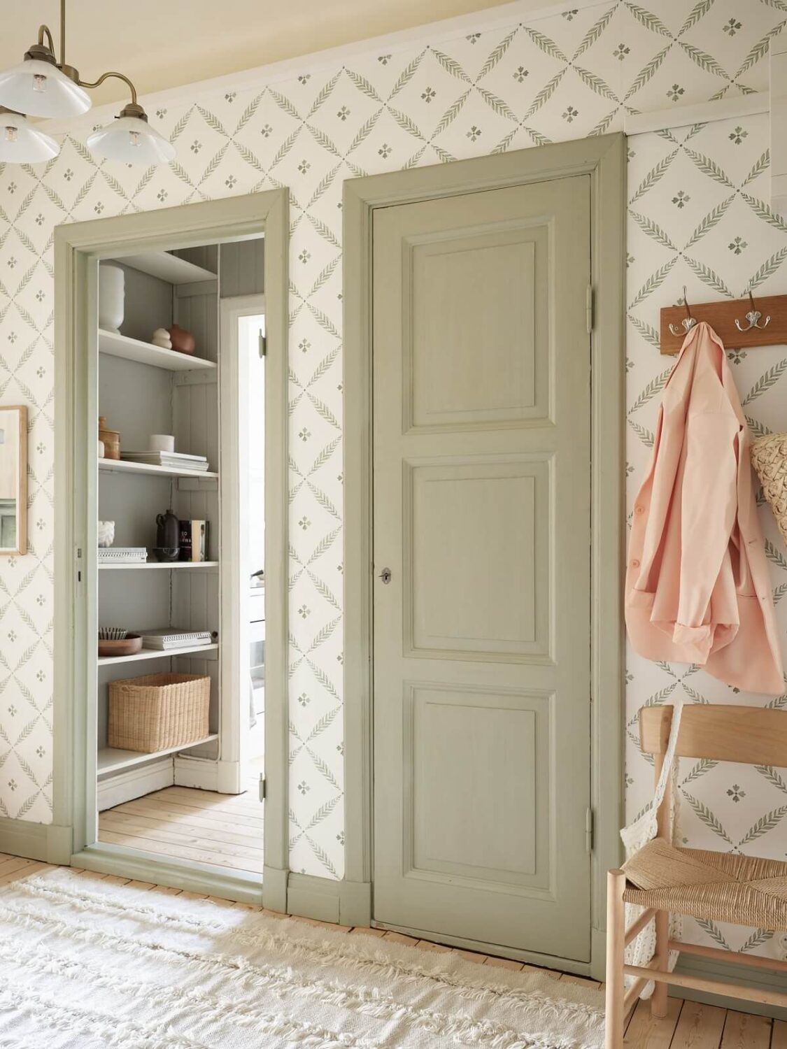 A Light Swedish Apartment with a Charming Kitchen 22 hallway with sage green doors and wallpaper nordroom