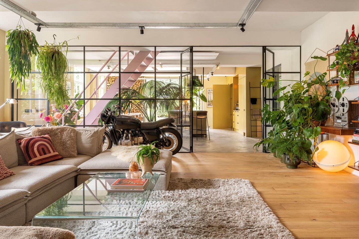 An Old Smokehouse Transformed Into a Modern Industrial Home 5 industrial glass wall between living room and kitchen