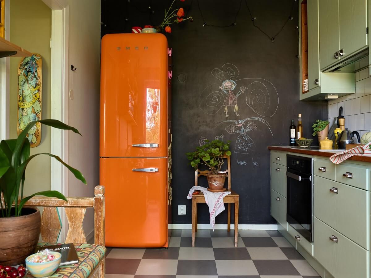A Charming and Cozy Midcentury Family Apartment in Sweden 12 kitchen chalk paint wall orange fridge nordroom