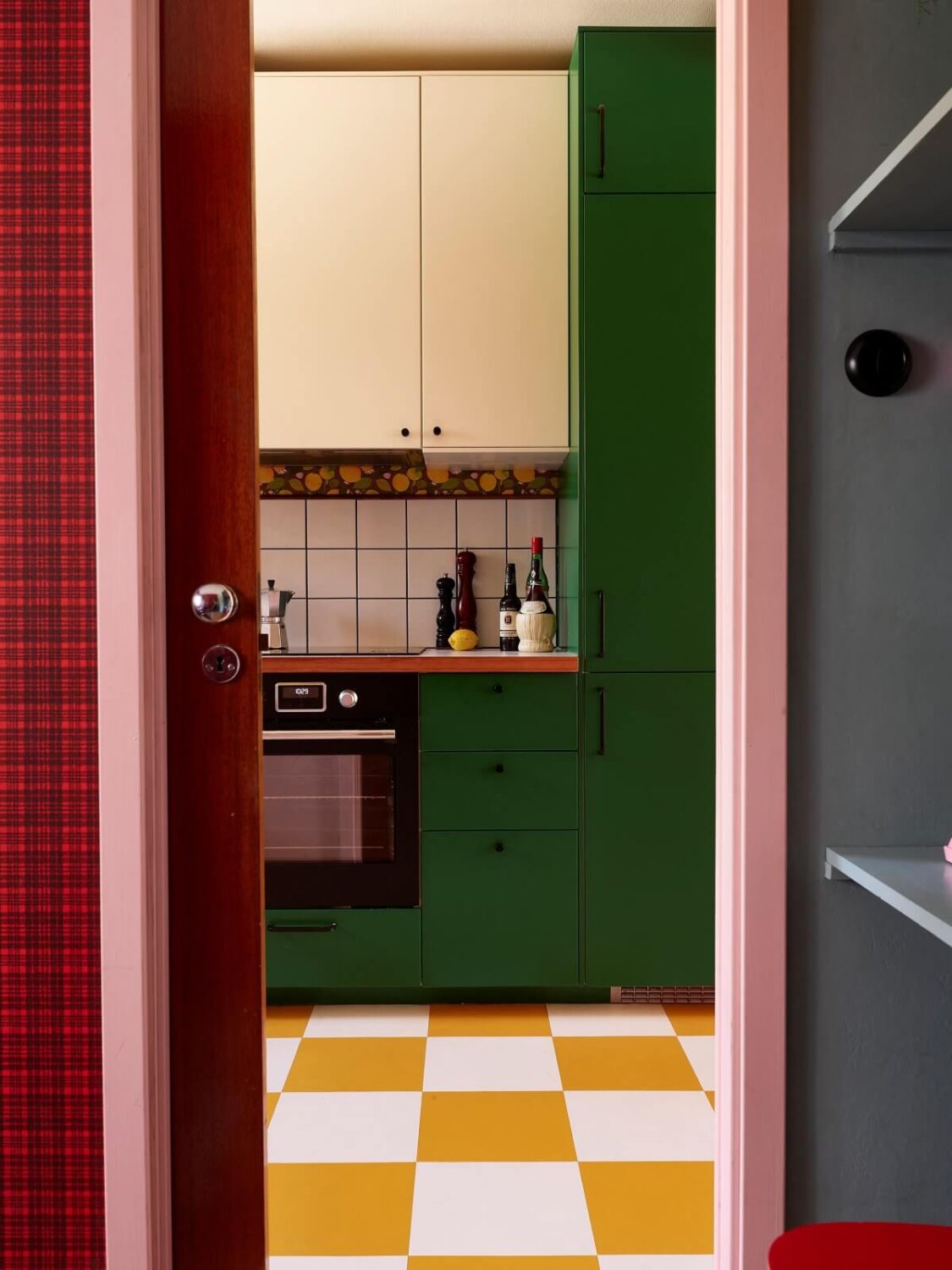 A Colorful Swedish Apartment Inspired by the 50s and 70s 4 kitchen green cabinets ochre yellow checkerboard floor nordroom