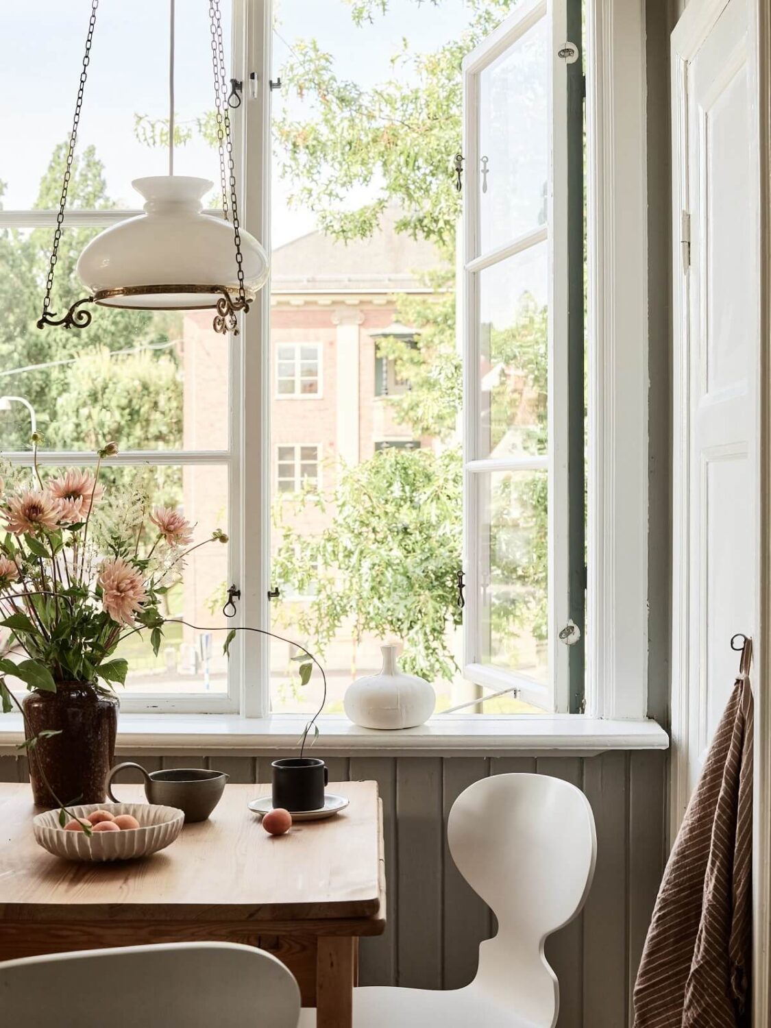 A Light Swedish Apartment with a Charming Kitchen 10 kitchen table in front of window