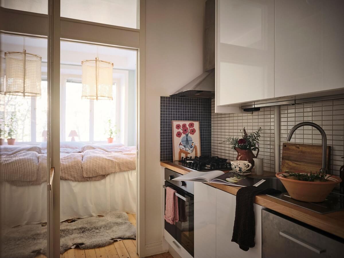 Muted Gray, Green, and Yellow Walls in a Stockholm Apartment 12 kitchen with glass wall to bedroom