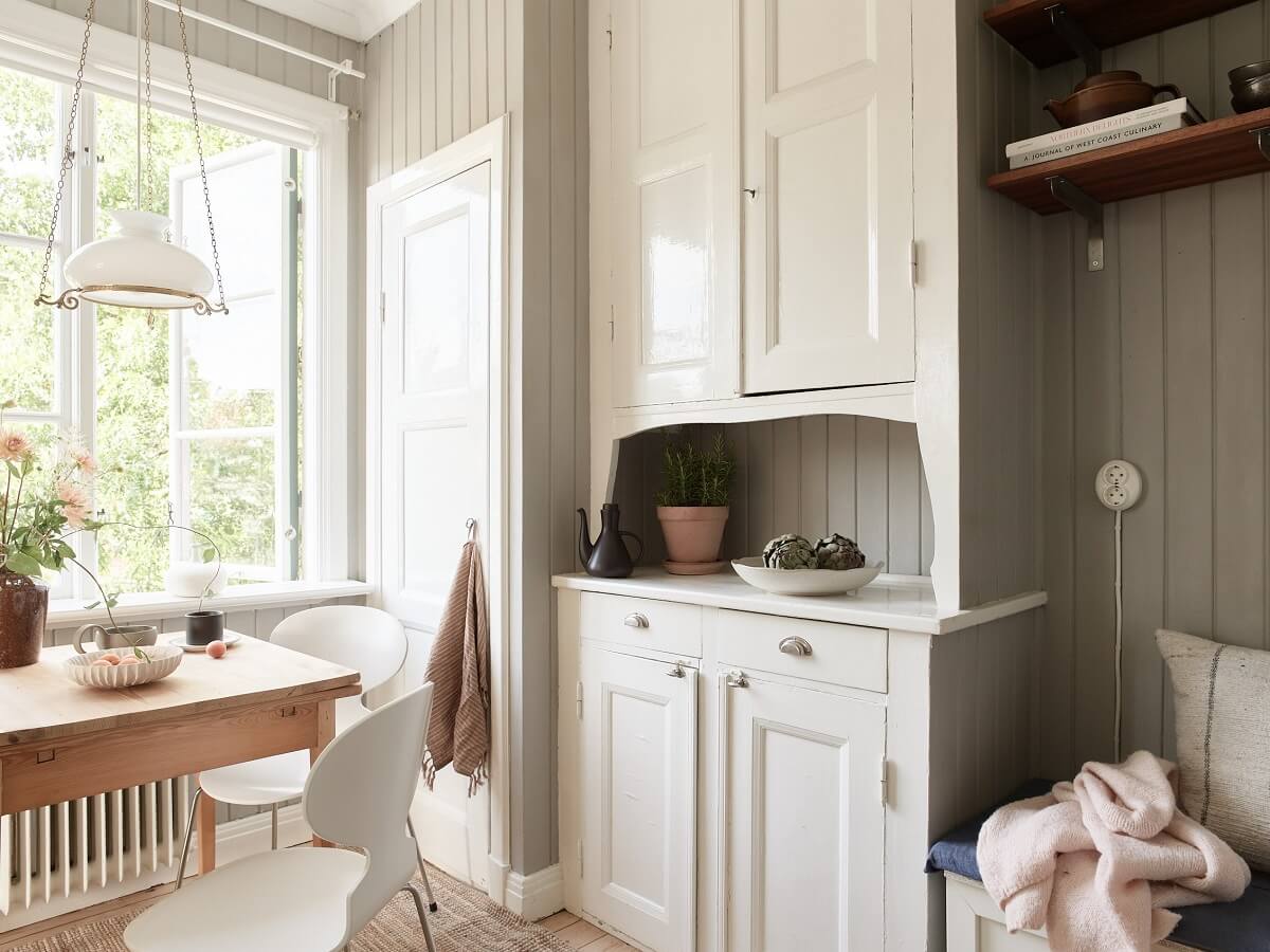 A Light Swedish Apartment with a Charming Kitchen 8 kitchen with original built in cabinets and table in front of the window nordroom