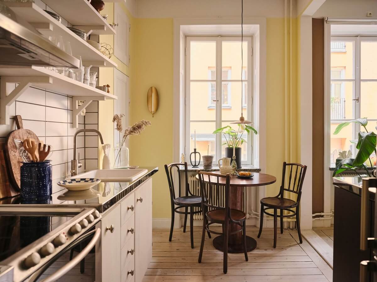 A Small Apartment with Calm Brown, Green, and Yellow Walls 9 kitchen with pale yellow walls and round table nordroom