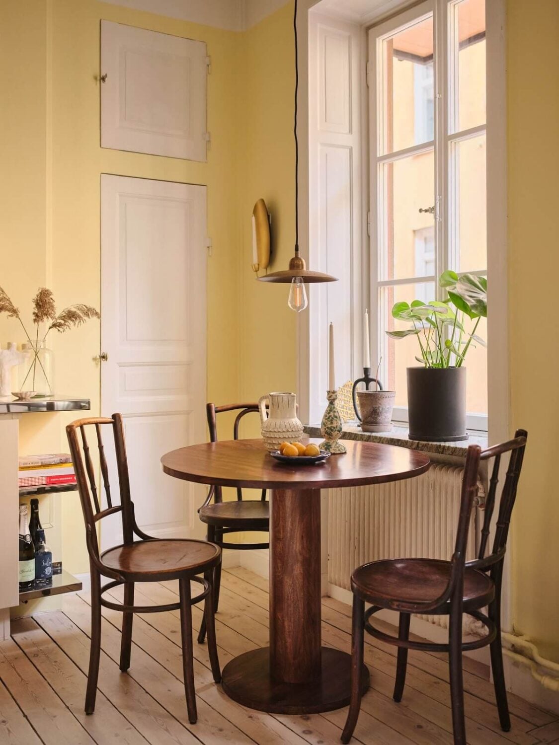 A Small Apartment with Calm Brown, Green, and Yellow Walls 7 kitchen with pale yellow walls and round wooden table nordroom