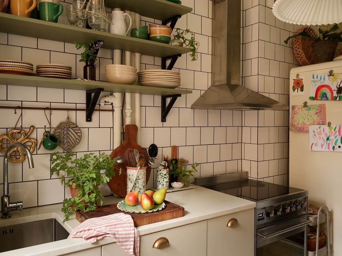 A Cozy 1920s Apartment with Original Details and Wallpaper 15 kitchen with white tiles and green shelves nordroom