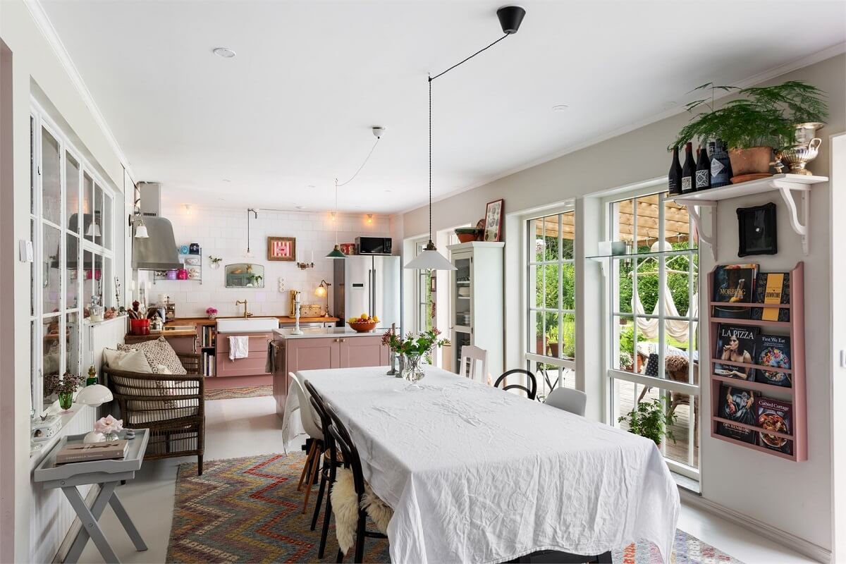 A Bright Open-Plan Swedish Home with a Pink Kitchen 7 large dining table in open plan kitchen space