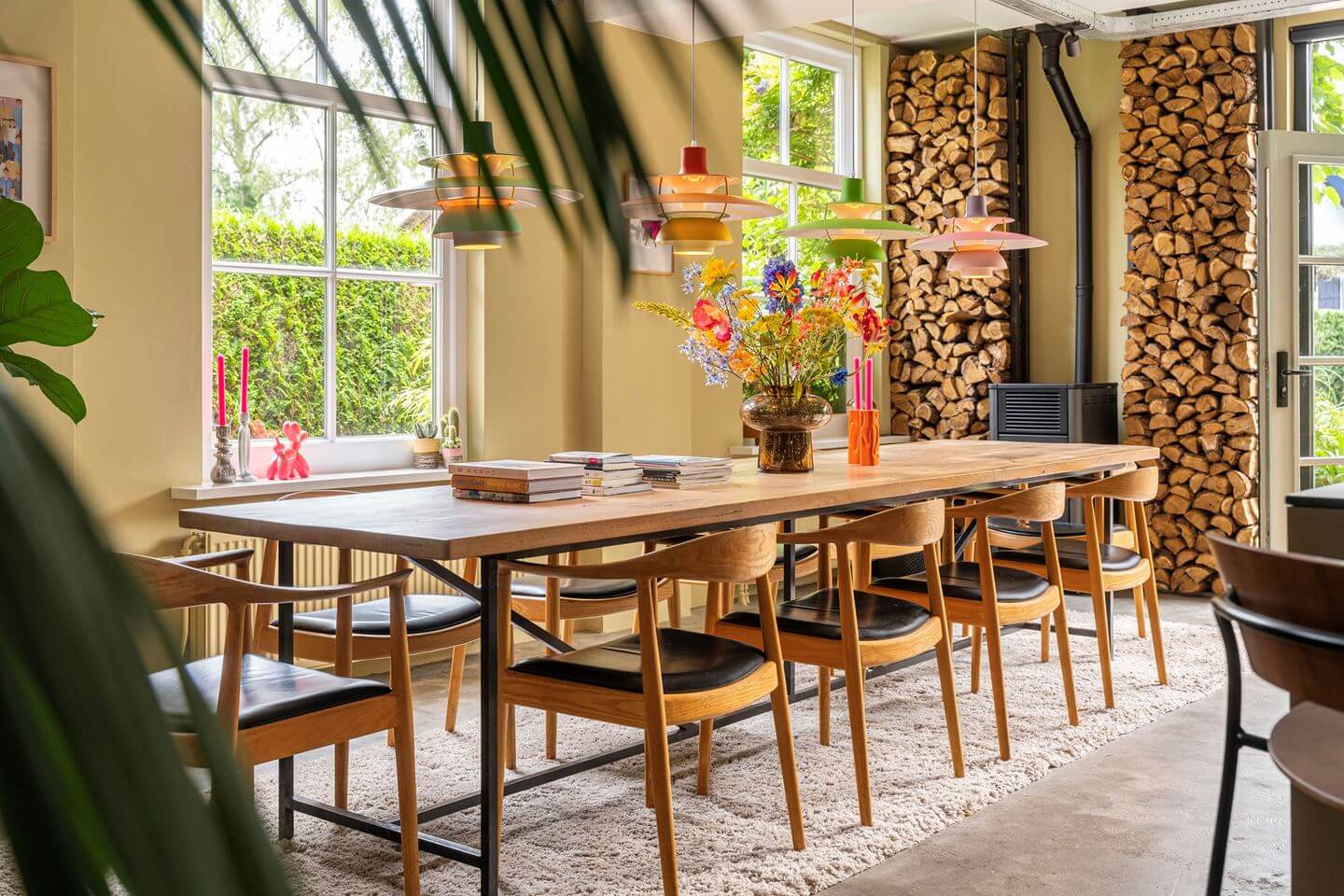 An Old Smokehouse Transformed Into a Modern Industrial Home 12 large dining table wood log feature wall