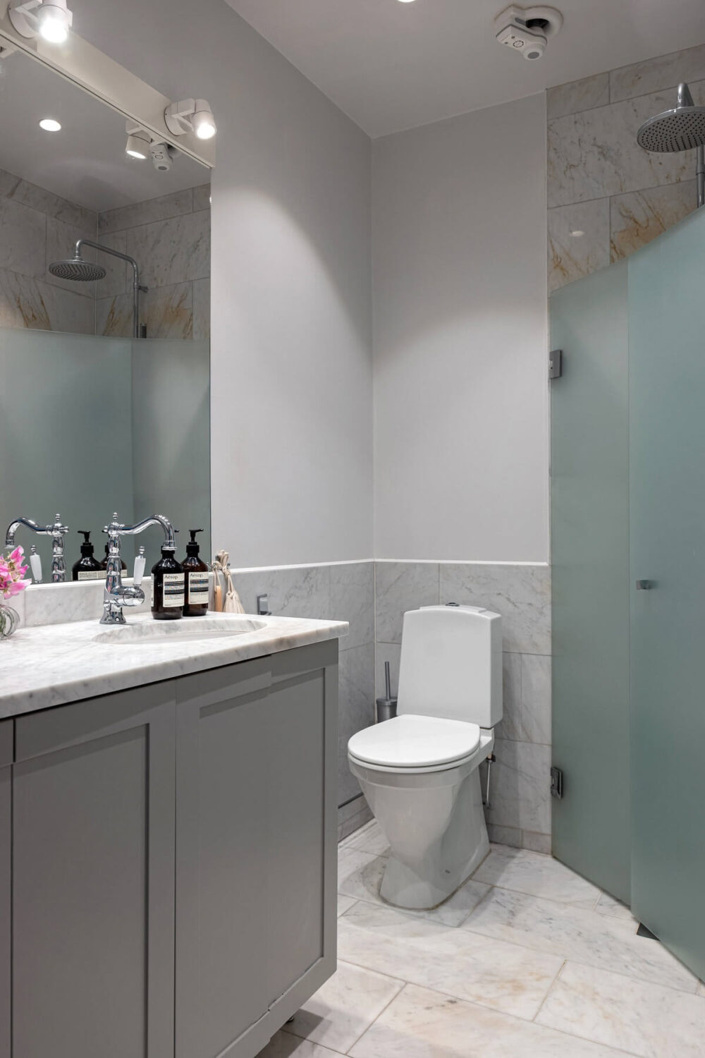 A Classic Apartment with a Blue Living Room 22 light gray bathroom