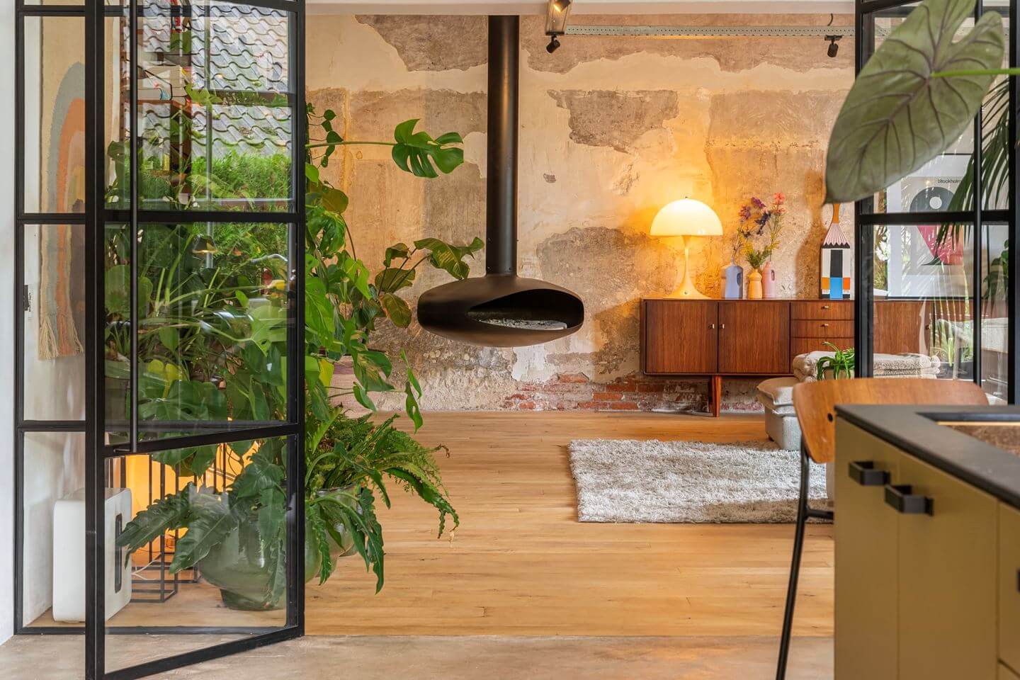 An Old Smokehouse Transformed Into a Modern Industrial Home 7 living room with hanging wood burner
