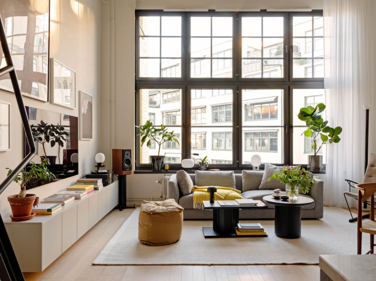 A Monochrome Loft with High Ceilings and Art 6 loft living space large windows low cabinets book yellow color accents