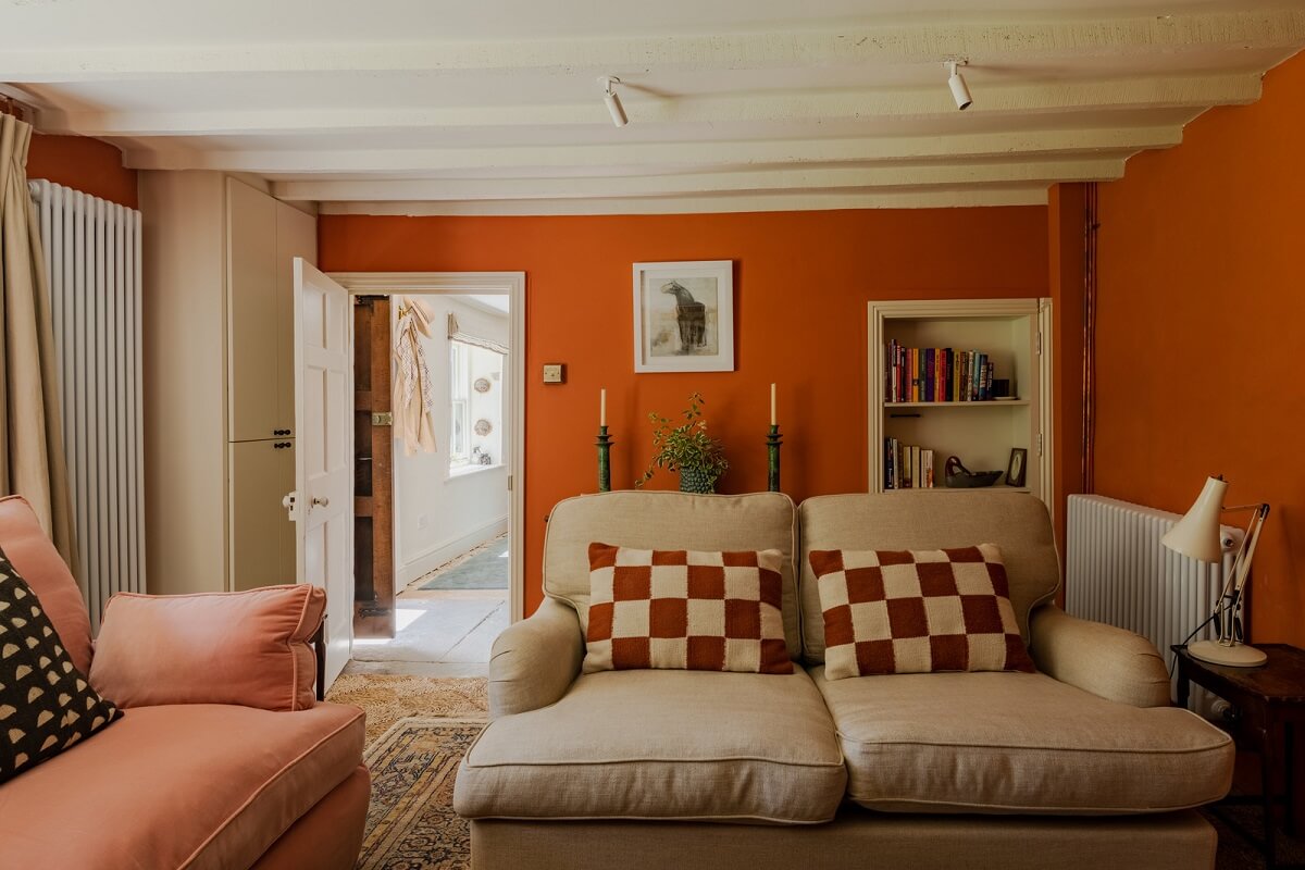 A Charming English Cottage with Historic Details 4 orange cottage sitting room checkerboard pillows
