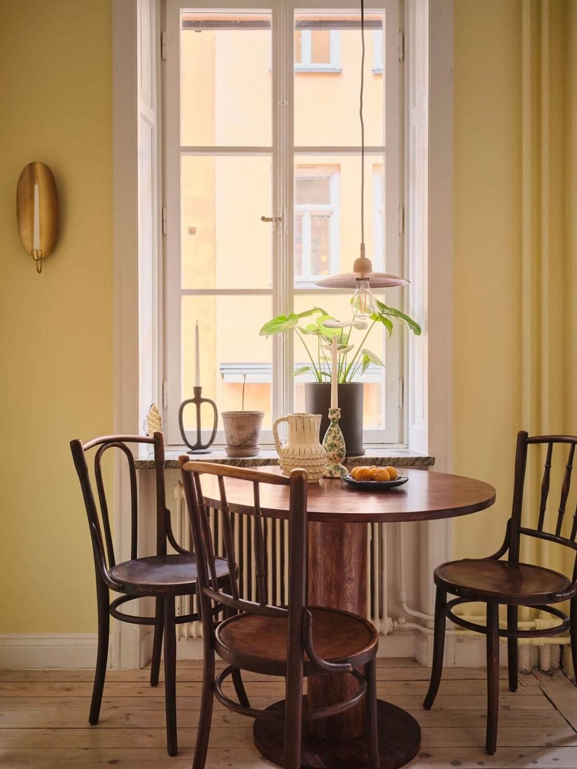 A Small Apartment with Calm Brown, Green, and Yellow Walls 8 pale yellow walls and round wooden table nordroom