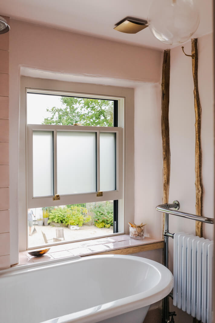 A Charming English Cottage with Historic Details 15 pink bathroom with bath in front of window nordroom A Charming English Cottage with Historic Details