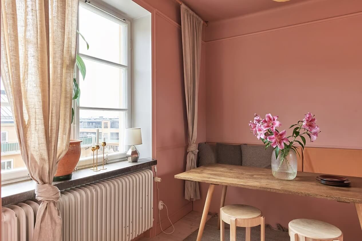 Warm Color-Drenched Rooms in a Swedish Apartment 14 pink dining room with bench and stools