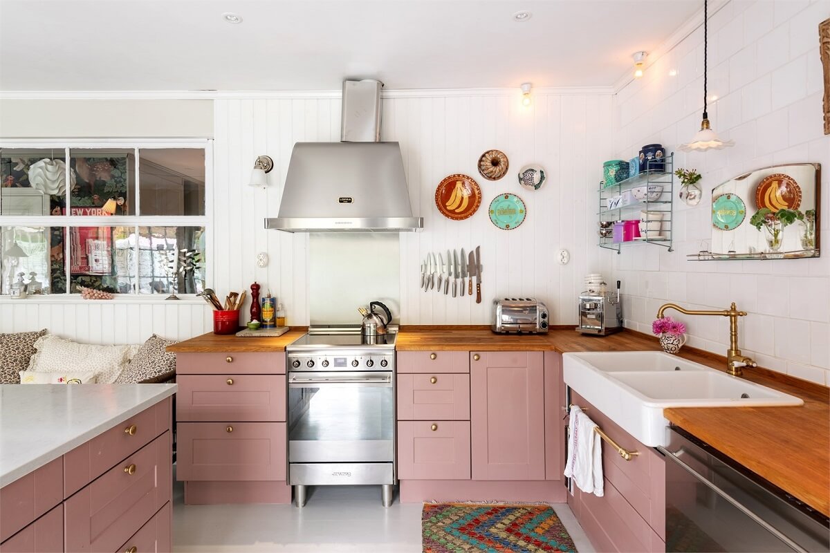 A Bright Open-Plan Swedish Home with a Pink Kitchen 11 pink kitchen with wooden worktop and butler sink