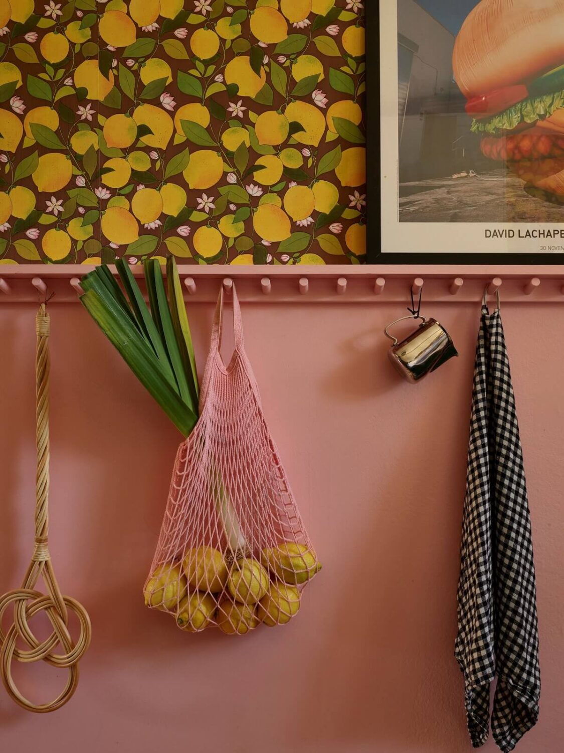 A Colorful Swedish Apartment Inspired by the 50s and 70s 5 pink wall with hooks and lemon wallpaper nordroom
