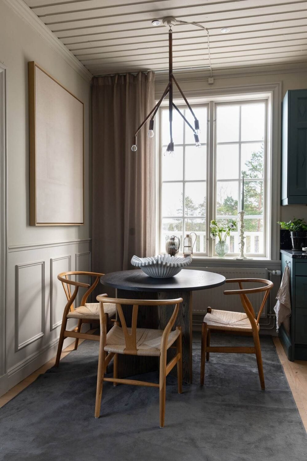 A Yellow Swedish Villa with Views of the Sea 9 round dining table wishbone chairs nordroom