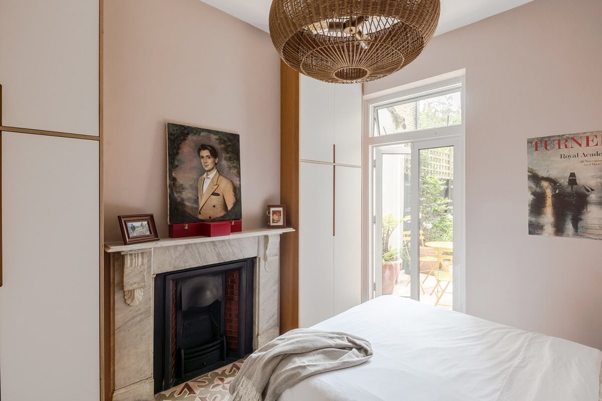 A London Apartment with a Deep Olive Green Kitchen 12 small light pink bedroom with fireplace and wardrobes nordroom
