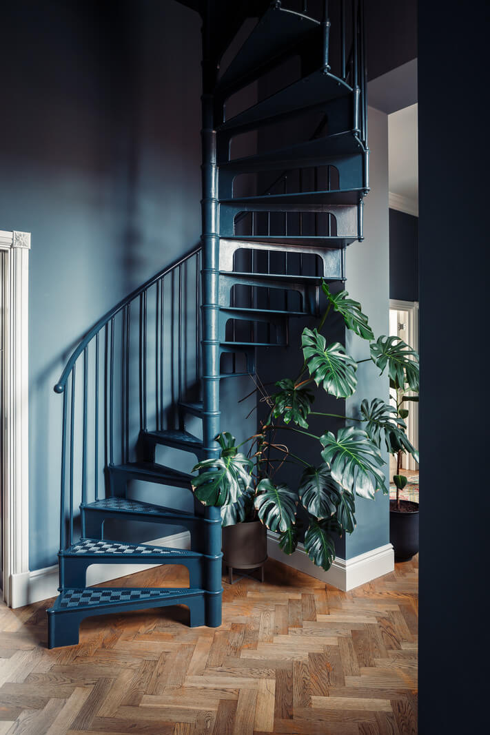 A London Duplex Apartment with a Purple Kitchen 8 spiral staircase in dark blue hallway