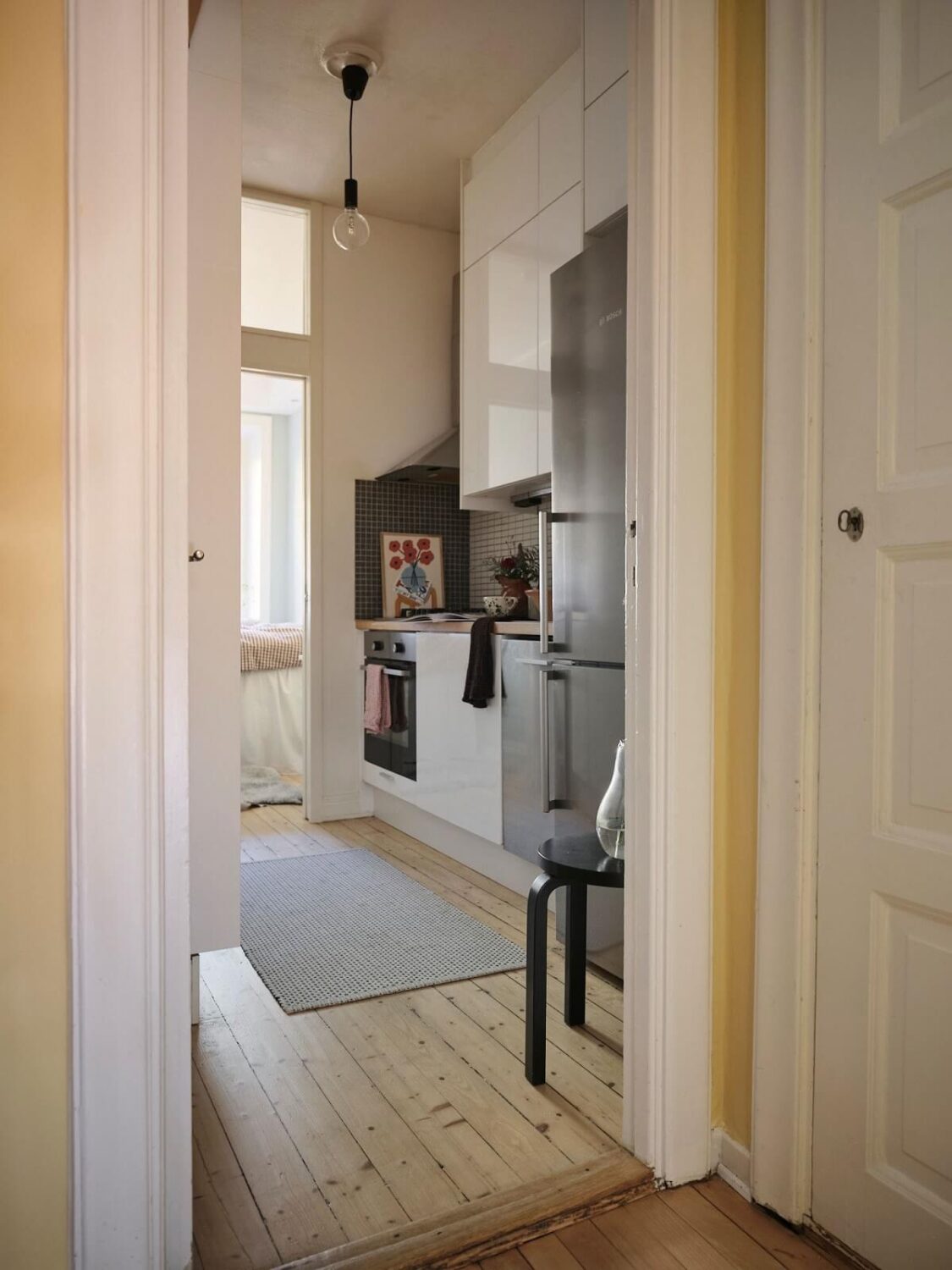 Muted Gray, Green, and Yellow Walls in a Stockholm Apartment 9 view into kitchen