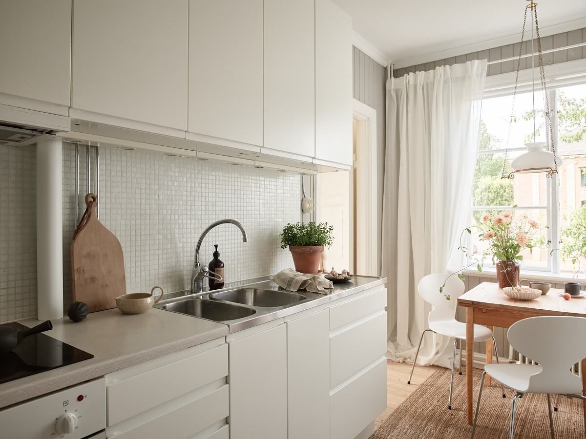 A Light Swedish Apartment with a Charming Kitchen 6 white kitchen with small table A Light Swedish Apartment with a Charming Kitchen