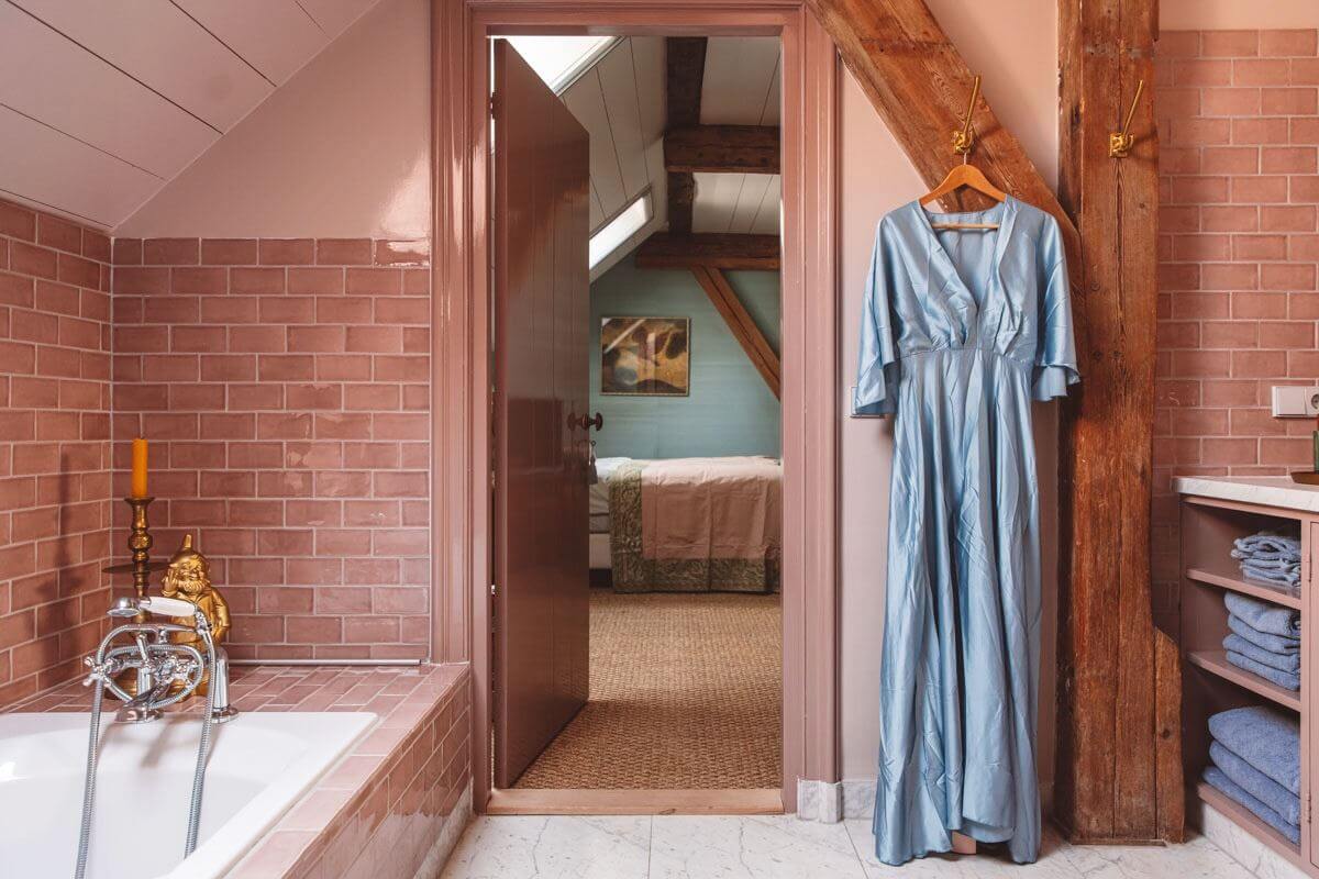 An Eclectic Colorful House in an Old Dutch Farmhouse 26 bathroom with bath wooden beam pink tiles
