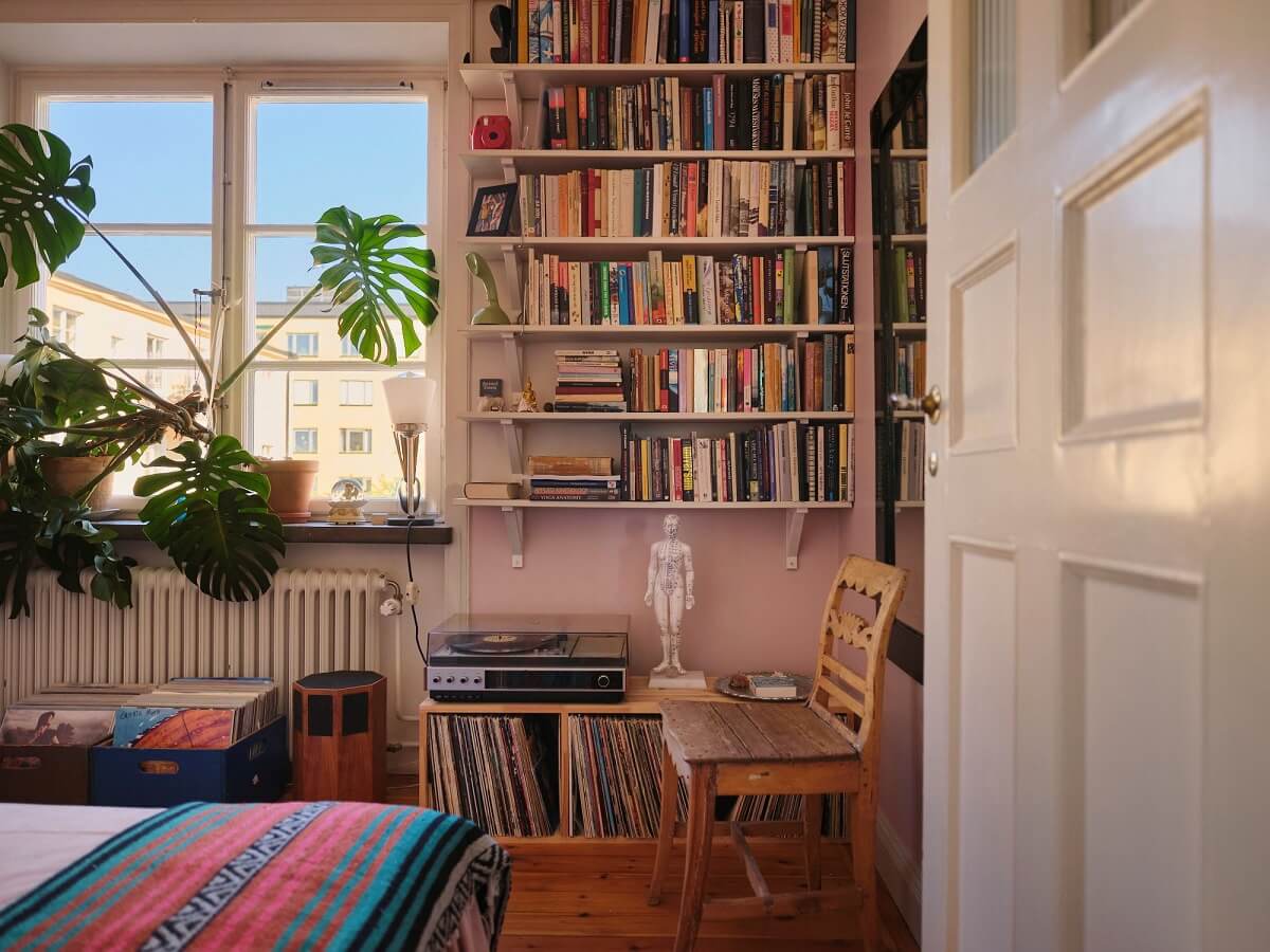 A Charming Small Two-Bedroom Apartment in Stockholm 19 bedroom with pink walls and bookshelves